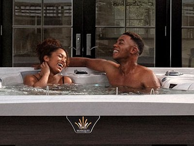 A couple enjoying the hydrotherapy effects of a Marquis hot tub