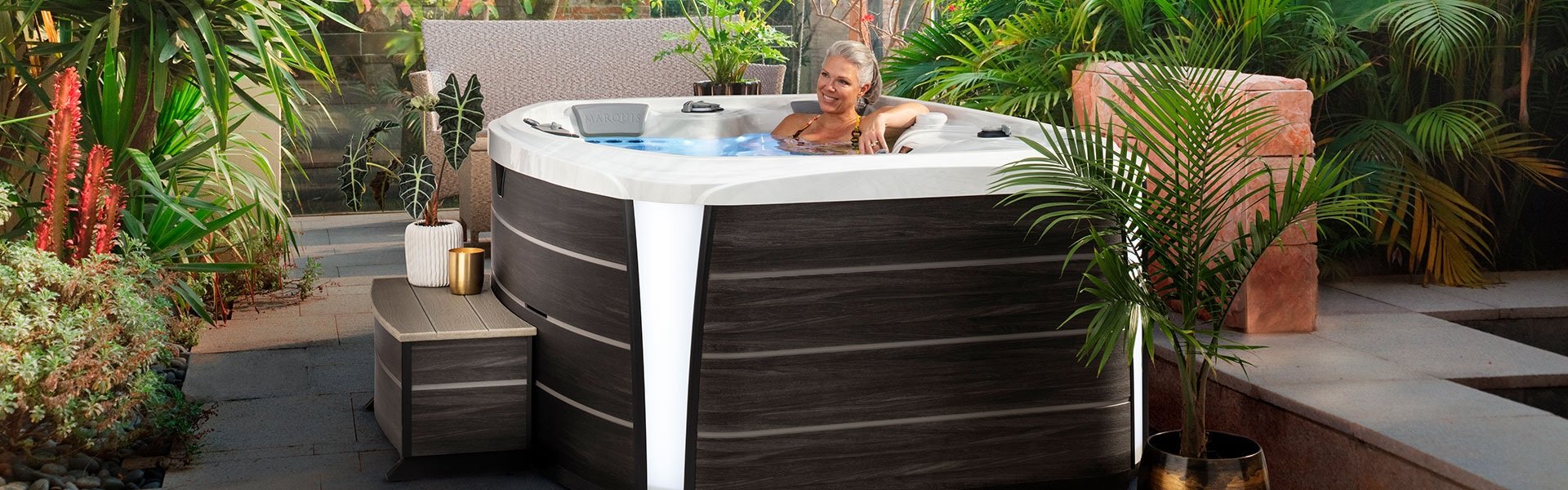 A woman sitting in a Marquis hot tub.