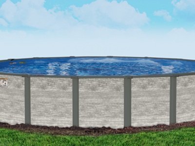 A round above-ground pool with decorative siding is set on a grassy lawn, accented by small landscaped mulch around its base.