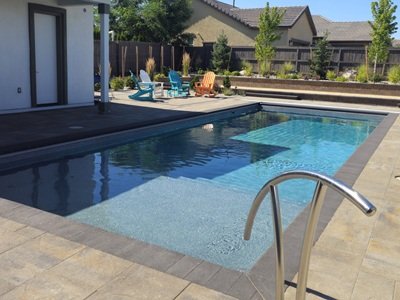 An inground swimming pool made of Fiberglass from Latham Pools in a residential backyard.